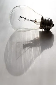 Light bulb on white surface. Stock Photos