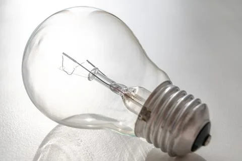 Light bulb on white surface. Stock Photos
