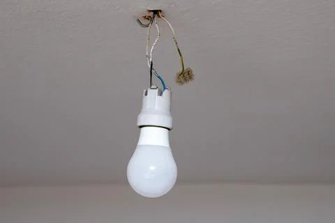Light bulb on a wire on the ceiling. Electricity at home. Danger. Foto stock