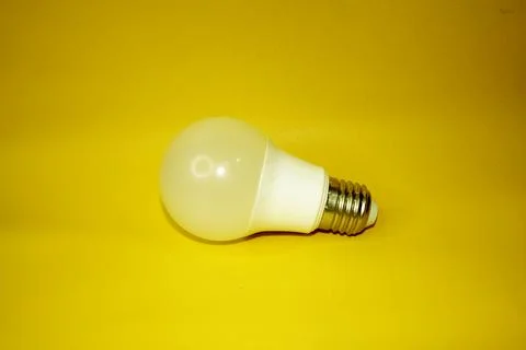 Light bulb on yellow background. Stock Photos