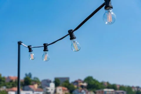 Light bulbs against a background of clear blue sky and horizon with Prague Stock Photos