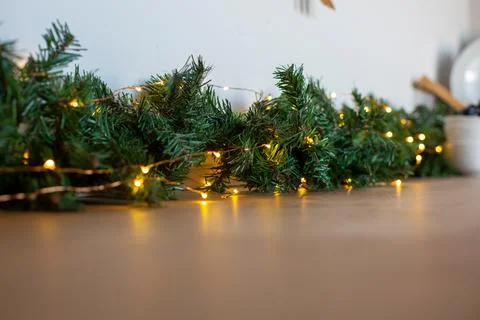 Light bulbs in coniferous branches on kitchen table. christmas atmosphere.home Stock Photos