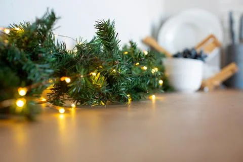 Light bulbs in coniferous branches on kitchen table. christmas atmosphere.home Stock Photos