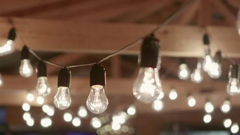 Light bulbs garland close up. Electric bulb shine hanging on wall as decoration Vídeo Stock 76565584