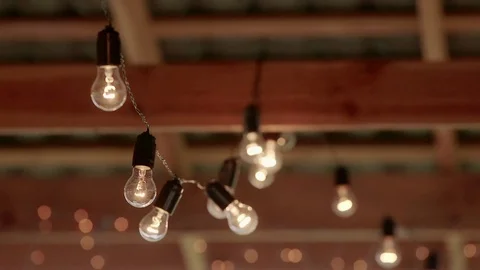Light bulbs garland close up. Electric bulb shine hanging on wall as decoration Video stock 76567351