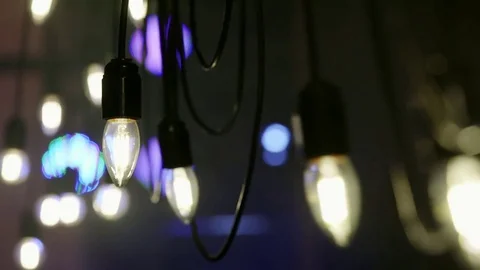 Light bulbs garland close up. Electric bulb shine hanging on wall as decoration Vidéo 80121028