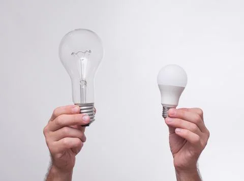 Light bulbs in the hands on a white background. Stock Photos