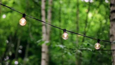 Light bulbs hang on a wire decorating the patio. Shooting in motion Stock Footage 337310890