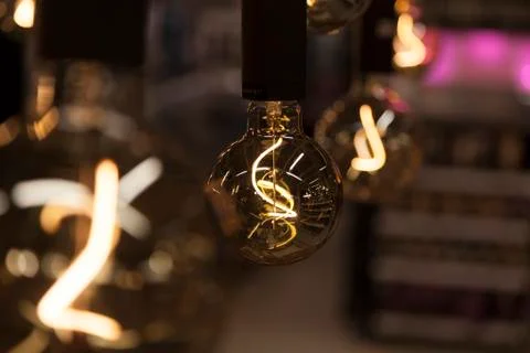 Light bulbs hanging from ceiling, abstract image with bokeh background Stock Photos