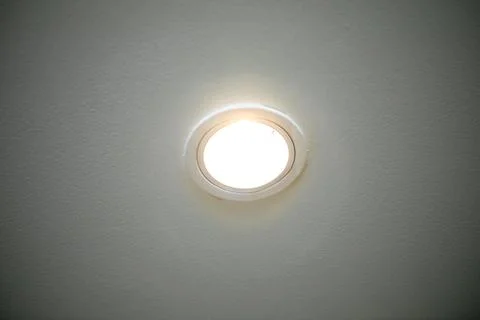Light bulbs mounted on the ceiling with a white background. Close-up. Stock Photos