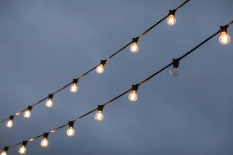Light bulbs on sky background. all work except one Illustrazione stock