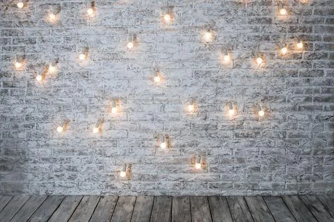 Light bulbs on white brick background with wooden floor. Vintage edison light Stock Photos