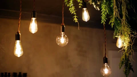 Light bulbs on wires hang down, illuminating the room and decorating the space. Stock Footage 329372695