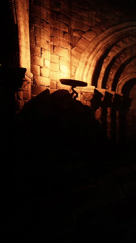 Light casting shadows on stone walls in an ancient setting at night Stock Footage 339421534