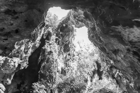 A light chimney passing through a cave with stalactites and stalagmites Stock Photos