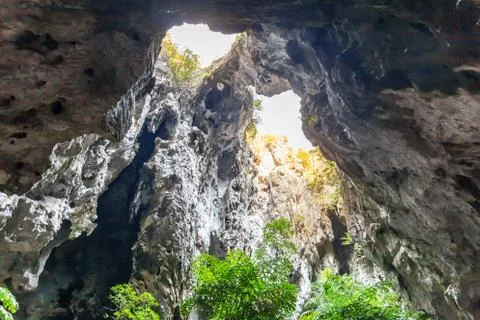 A light chimney passing through a cave with stalactites and stalagmites Stock Photos