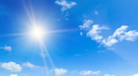 Light clouds and bright sun in blue sky. Stock Photos