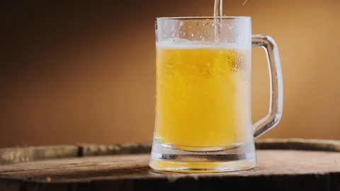 Light cold beer is poured into a beer glass Stock Footage 125638296