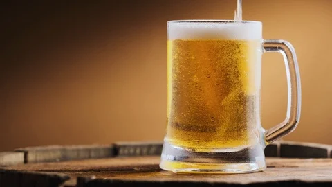 Light cold beer is poured into a beer glass Stock Footage 125638311
