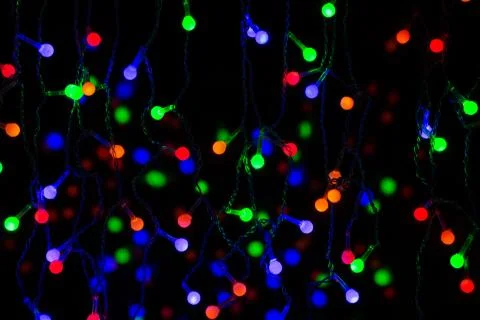 Light colored garlands on a dark background Stock Photos