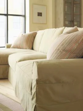 Light colored sofa with striped throw pillow Stock Photos