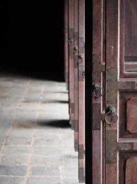 Light coming to the temple through opened wooden ancient door. Stock Photos