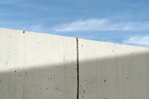 Light concrete wall texture under blue sky creates minimalist urban backgroun Photos