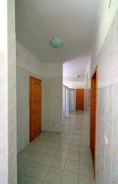 A light corridor surrounded by a tile with a brown wooden door in the locker  Stock Photos
