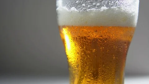Light craft beer, the bubbles rise up. A misted glass, a drop drains. Stock Footage 123051839