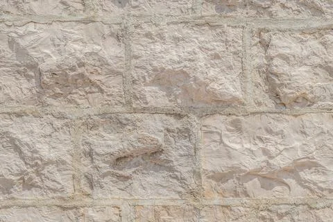 Light cream texture of the wall surface, built of rectangular natural bricks Stock Photos