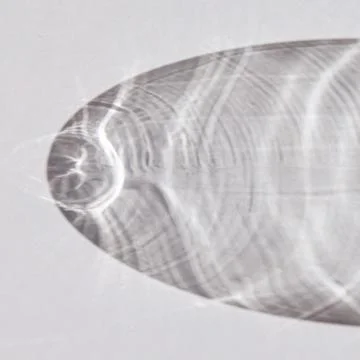 Light creates caustic patterns on a flat glass surface Stock Photos