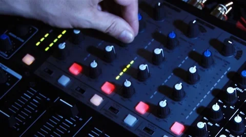 Light creates shadows on the buttons of a mixer which is used by a DJ Stock Footage 64348642