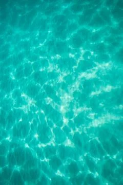 Light dancing on the sand below a tropical turquoise blue ocean Stock Photos