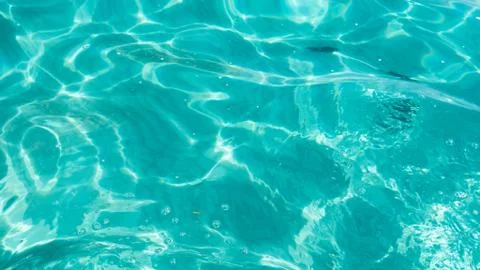 Light dancing on the sand below a tropical turquoise blue ocean Stock Photos