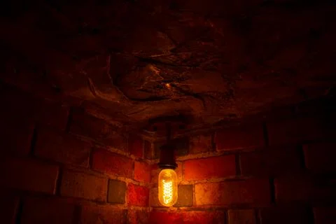 Light in the dark, old lamp on the wall, old brick wall with light Stockfoto's