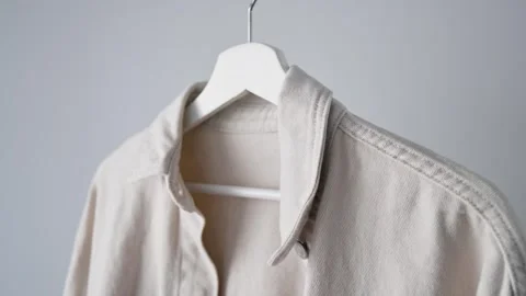 Light denim outerwear on white hanger highlights timeless casual fashion Stock Footage 340266670