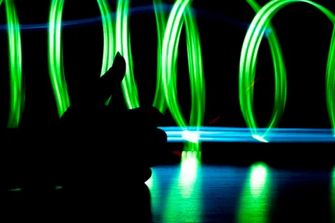 Light effect. Multicolored blurred lines on a black background. Black silhouette Stock Photos