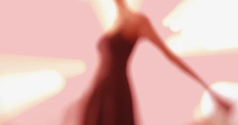 In the light - an elegant woman is dancing in front of an abstract background Vidéo 104241009