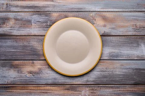 Light empty plate with brown edge on from boards wooden background, top view Stock Photos