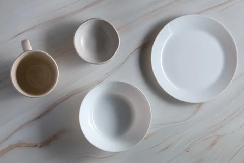 Light empty plates without food on light marble background, flat lay, top view. Stock Photos
