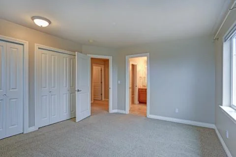 Light empty room interior with bathroom and built in closet. Stock Photos