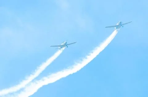 Light engine airplane with a trace of white smoke fly in groups in the blue s Stock Photos