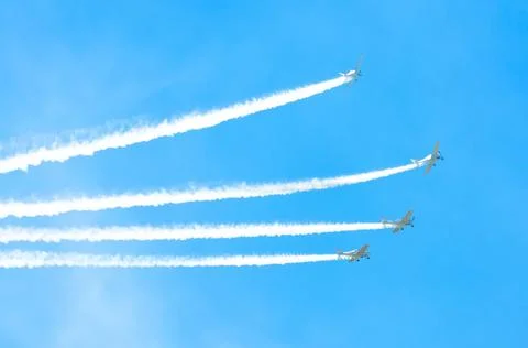 Light engine airplane with a trace of white smoke fly in groups in the blue s Stock Photos