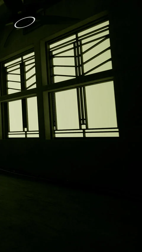 Light enters a room through unique windows on a dimly lit wall Stock Footage 339939739