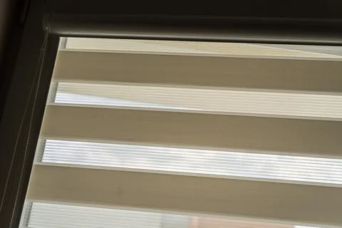 Light filtering roller blinds partially open to allow natural light into the Stock Photos