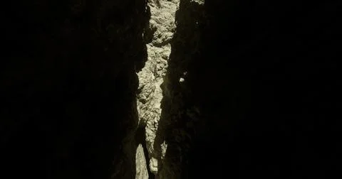 Light filtering through a narrow canyon highlighting rocky textures Stock Illustration