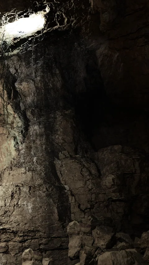 Light filters through an opening in a cave showing rough stone walls Stock Footage 331744632