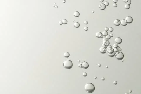 Light fizz bubbles soars over a grey blurred background Stock Photos