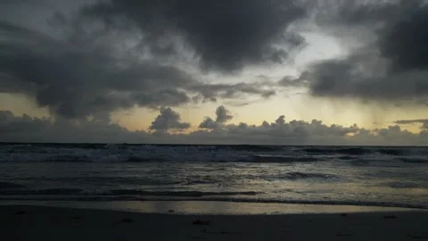 Light flickers on the sea and beach yellow and dark sky 6K Stock Footage 311900115