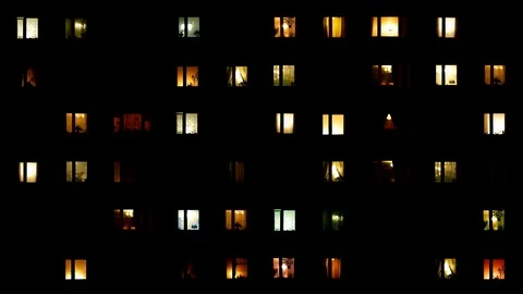 Light flickers in the windows of a multistory building. Video stock 106209476